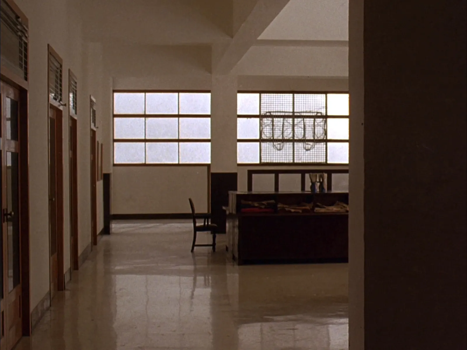 a quiet corridor inside a government administration office in India, frosted windows and teak doors, morning light